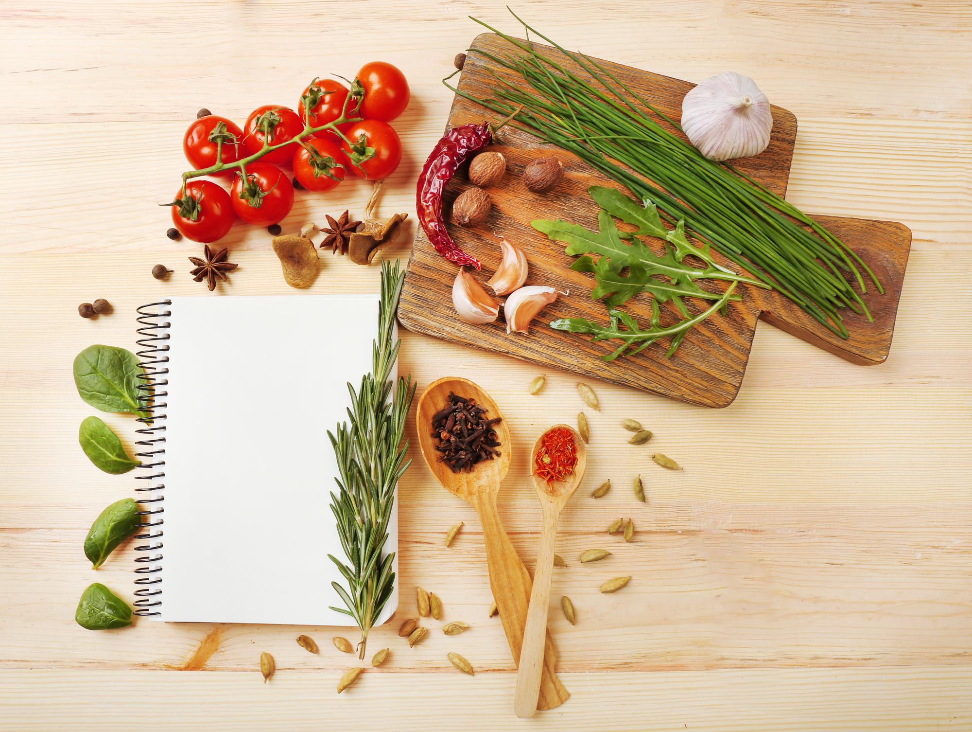 Tavola con ingredienti freschi e quaderno di ricette